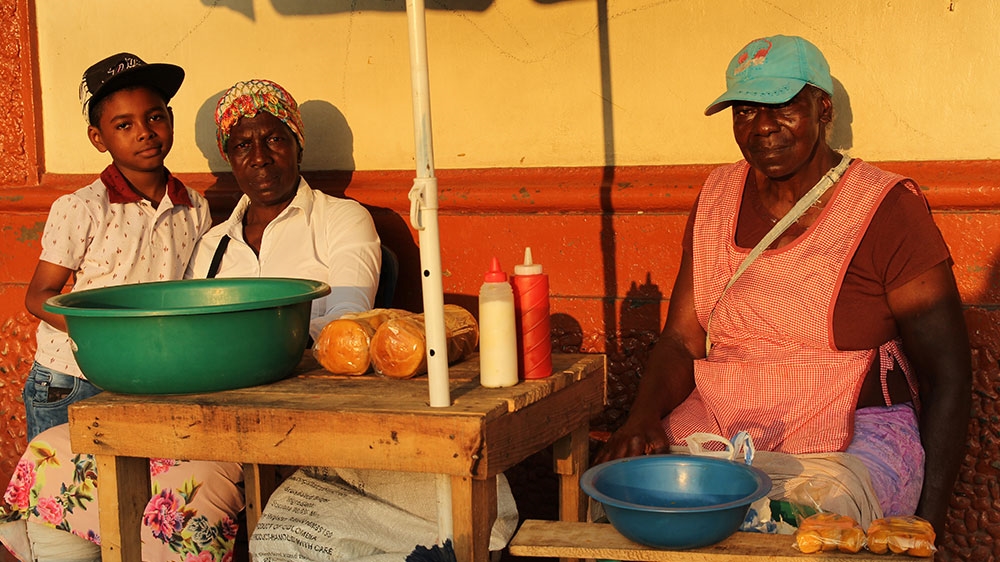 Two women who were forced to flee violence in their home in Buenaventura during the war, now sell street food in Santander de Quilochao, Colombia [Kimberley Brown/Al Jazeera]