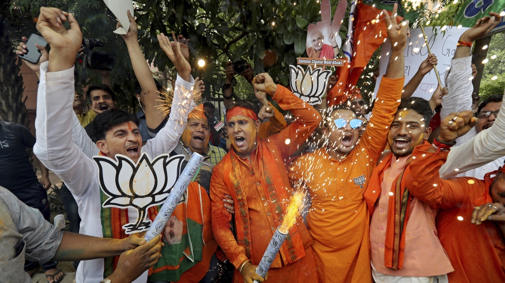 Bharatiya Janata Party (BJP) workers celebrate outside BJP headquarters in New Delhi India, Thursday, May 23, 2019. Indian Prime Minister Narendra Modi and his party have a commanding lead in early vo