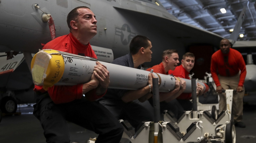 US Navy personnel aboard the aircraft carrier USS Abraham Lincoln [Jeff Sherman/AP]