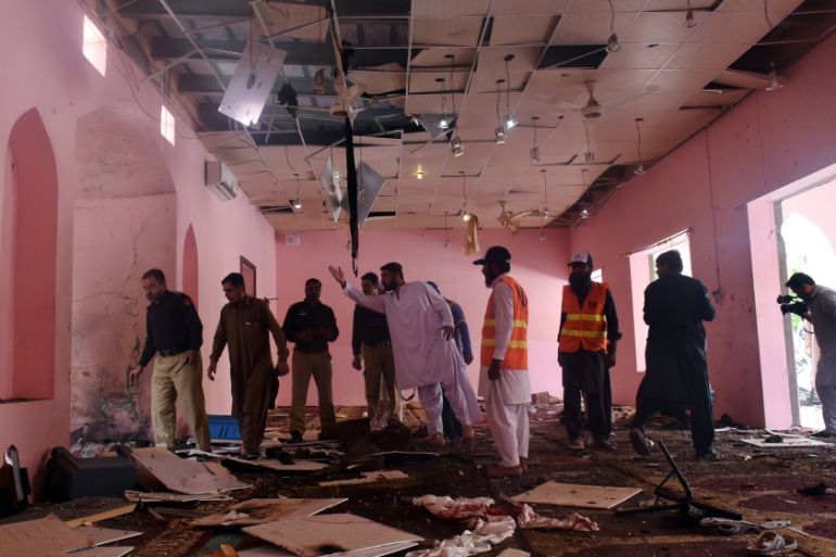 Police officers and rescue workers gather at the site after a blast in a mosque in Quetta,