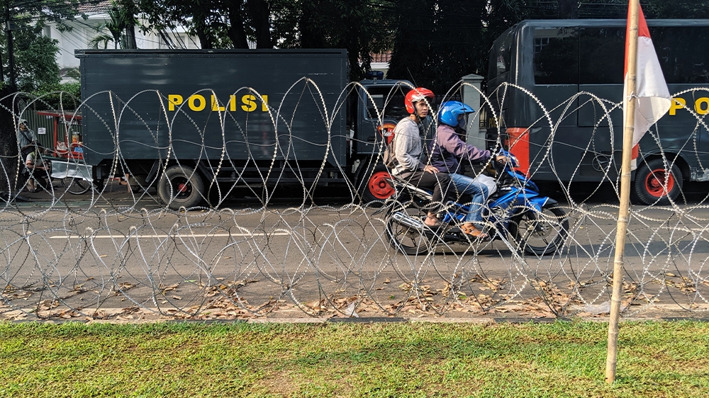 Razor wire and police trucks deployed outside the headquarters of Indonesia's election commission amid concerns about street protests called by hardline Islamic groups and losing presidential candidate Prabowo Subianto. [Kate Walton/Al Jazeera]