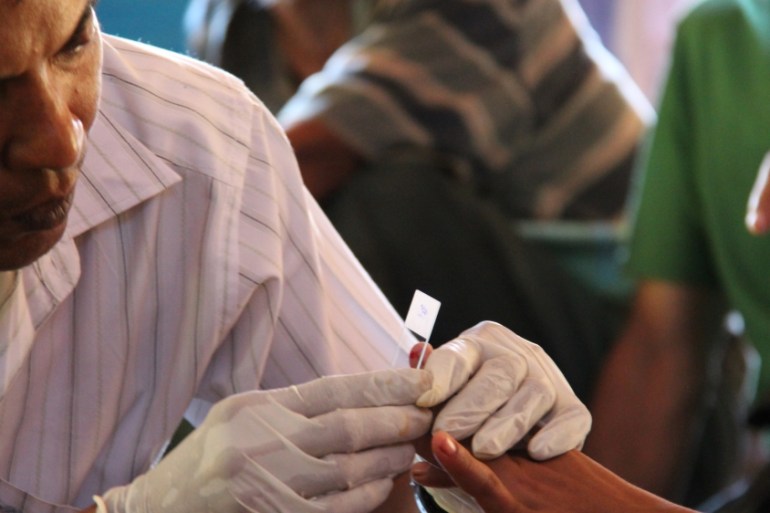 A government health worker takes a blood sample to be tested for malaria in Ta Gay Laung village hall in Hpa-An district in Kayin state, south-eastern Myanmar