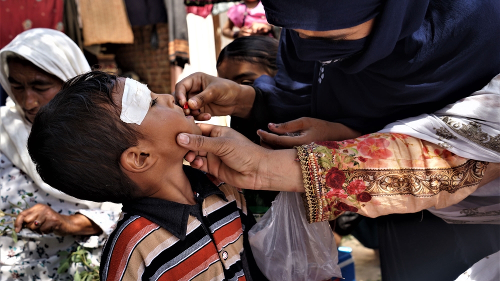 A child receives supplementary Vitamin A capsules during the polio campaign under the National Emergency Action Plan for Polio Eradication [Sabrina Toppa/Al Jazeera]