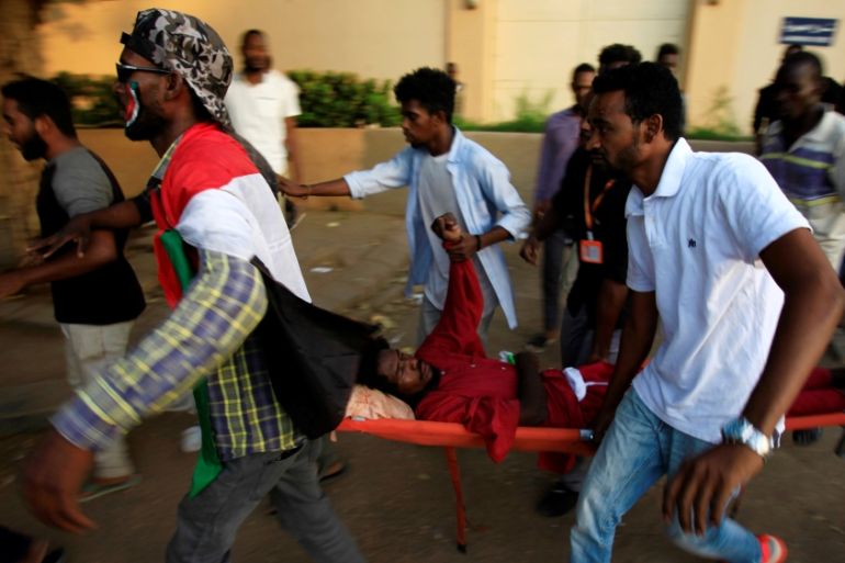 Civilians evacuate a Sudanese protester injured during demonstrations along a street in central Khartoum, Sudan May 15, 2019