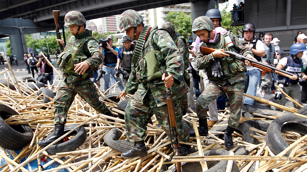 Thai army soldiers cross a destroyed barricade during the 2010 crackdown on the so-called Red-Shirt protesters who had occupied Bangkok for three months [File: Damir Sagolj/Reuters]