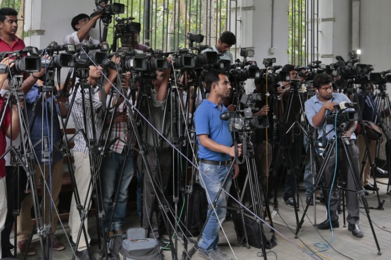 In this May 3, 2016 file photo, Bangladeshi journalists cover proceedings outside a court in Dhaka, Bangladesh. An influential body of newspaper editors in Bangladesh has criticized the government for