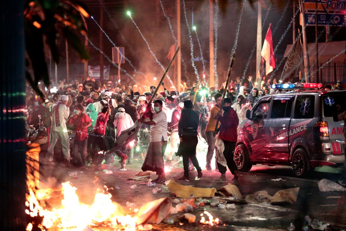 Fire crackers explode near supporters of presidential candidate Prabowo Subianto during clashes with the police in Jakarta, Indonesia, Wednesday, May 22, 2019. Indonesian President Joko Widodo said au
