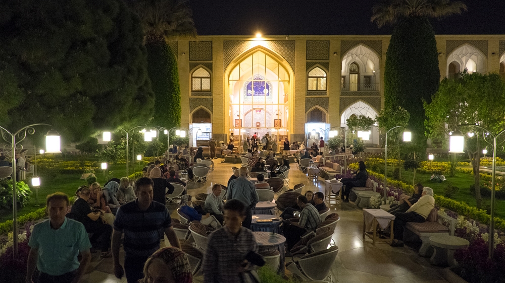 Visitors sip tea in the courtyard of the landmark Abbasi Hotel [Wojtek Arciszewski/Al Jazeera]