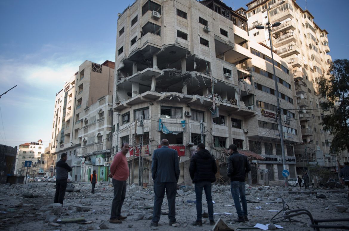 Palestinians stand in front of a destroyed multi-story building was hit by Israeli airstrikes late Saturday in Gaza City, Sunday, May 5, 2019. Palestinian militants on Saturday fired over 200 rockets