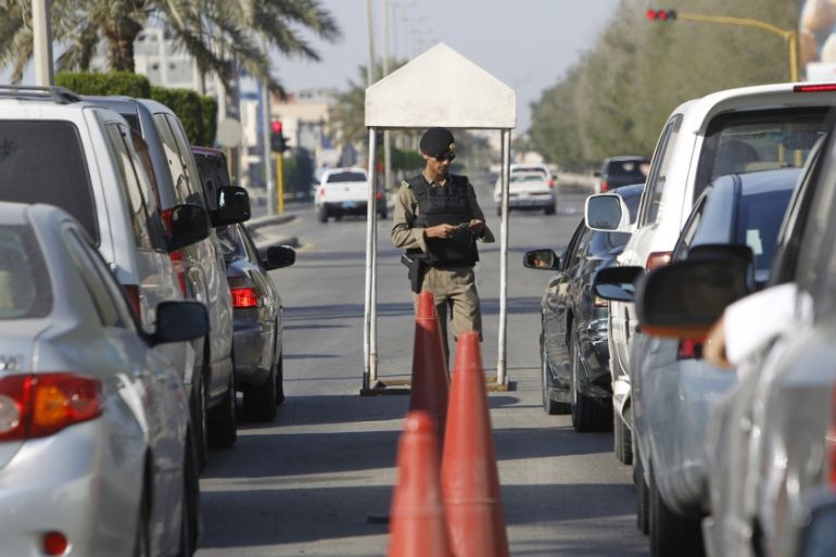 A Saudi police officer checks cars at a security checkpoint in Saudi Arabia''s eastern Gulf coast town of Qatif