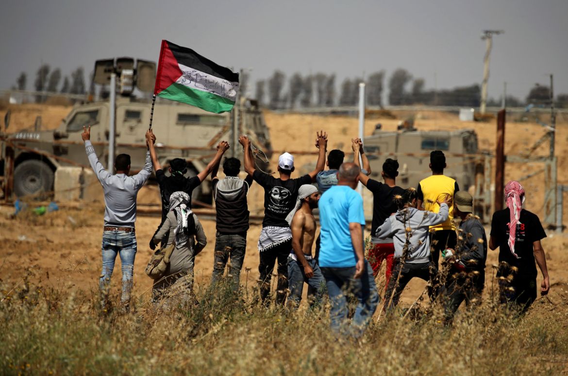 Palestinian demonstrators gesture in front of Israeli forces during a protest marking the 71st anniversary of the ''Nakba'', or catastrophe, when hundreds of thousands fled or were forced from their hom