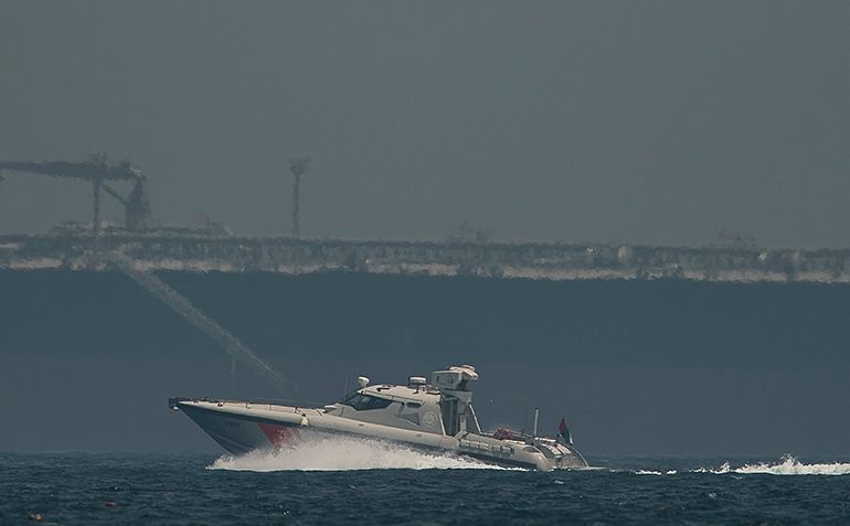 An Emirati coast guard vessel passes an oil tanker off the coast of Fujairah, United Arab Emirates, Monday, May 13, 2019. Saudi Arabia said Monday two of its oil tankers were sabotaged off the coast o