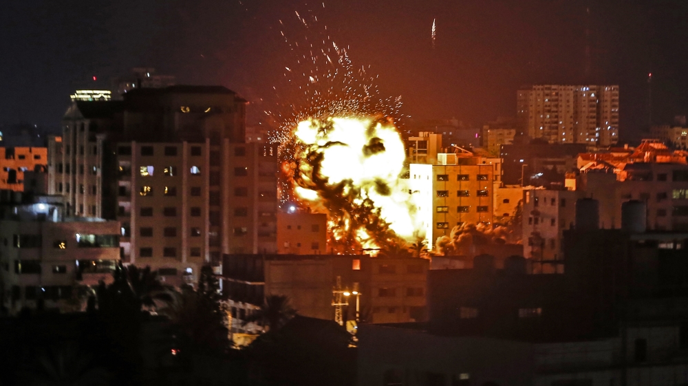 An explosion is pictured among buildings during an Israeli air raid on Gaza City [Mahmud Hams/AFP]