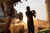 Fighters loyal to Libya's UN-recognised government (GNA) fire guns during clashes with forces loyal to Khalifa Haftar on the outskirts of Tripoli on May 25 [Reuters/Goran Tomasevic]
