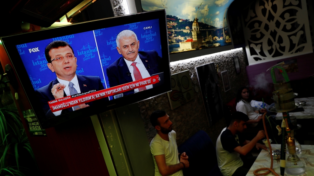 People watch a televised debate between Istanbul's mayoral candidates Imamoglu of CHP and Yildirim of AKP at a cafe in central Istanbul