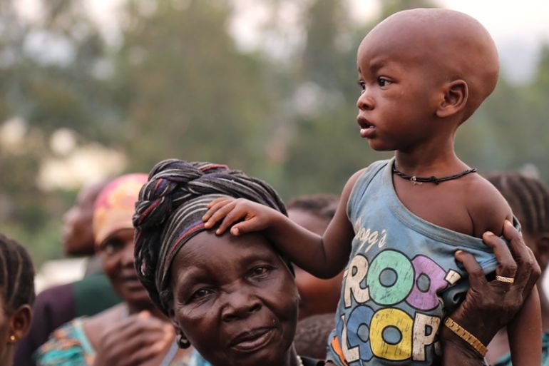 A woman holds a child on her shoulders in an Internally Displaced Persons Camp outside the town of Bunia, in Ituri province, on June 21, 2019.
