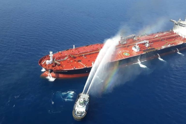 An Iranian navy boat tries to stop the fire of an oil tanker after it was attacked in the Gulf of Oman