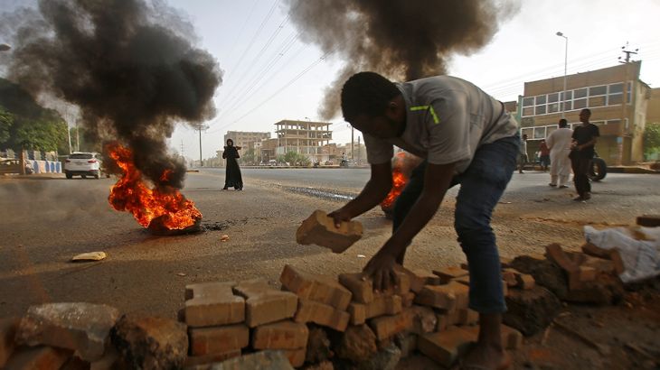 A Sudanese protester uses paving stones to block Street 60 as military forces tried to disperse the sit-in outside Khartoum''s army headquarters on June 3, 2019. - At least two people were killed Monda