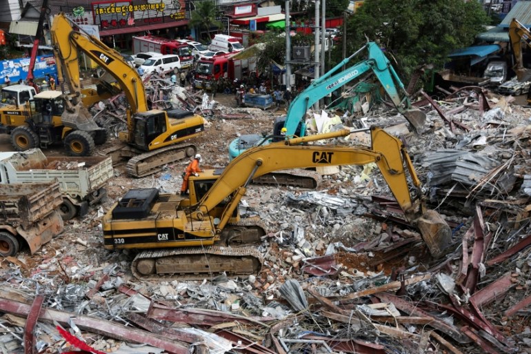 Rescue workers use earthmovers to clear debris as they search for victims a day after an under-construction building collapsed in Sihanoukville on June 23, 2019. At least 17 people are dead after a Ch