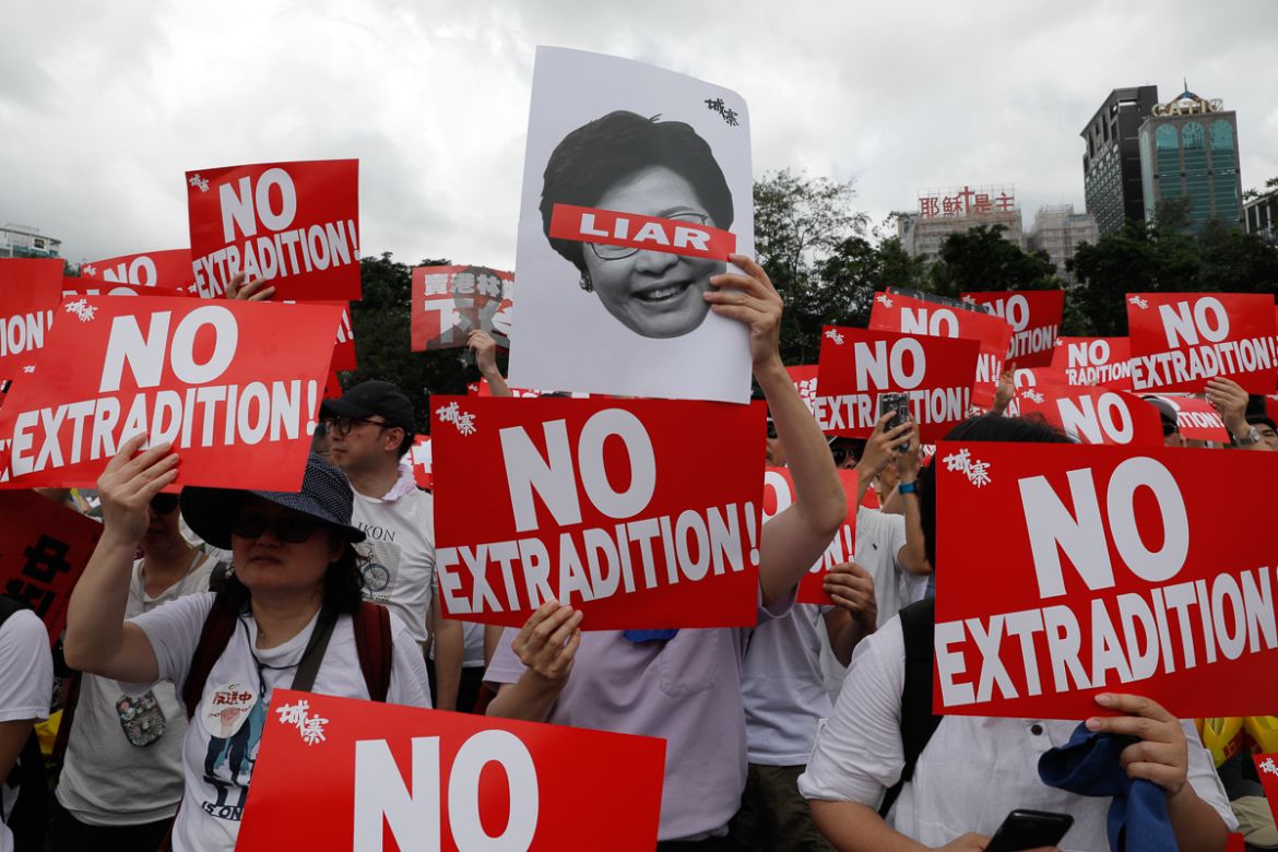 Protesters hold placards as they stage protest against the extradition law in Hong Kong, Sunday, June 9, 2019. The extradition law has aroused concerns that this legislation would undermine the city''s