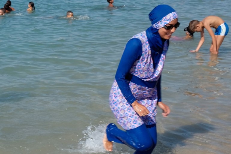 A woman wearing a burkini walks in the water August 27, 2016 on a beach in Marseille, France, the day after the country''s highest administrative court suspended a ban on full-body burkini swimsuits t