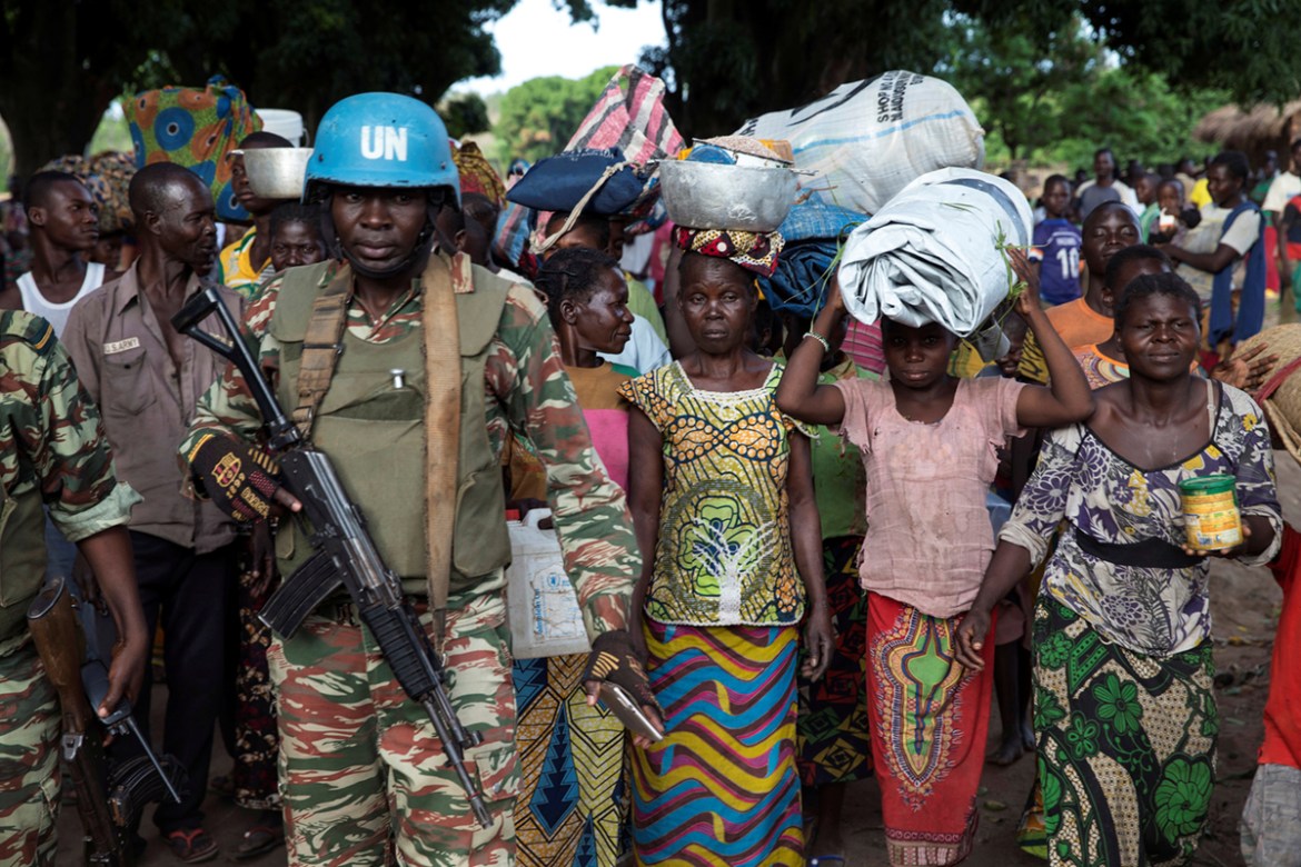 A Cameroonian United Nations peacekeeping soldier guards women fleeing the village of Zike as they arrive to the village of Bambara, Central African Republic, April 25, 2017. Picture taken April 25, 2