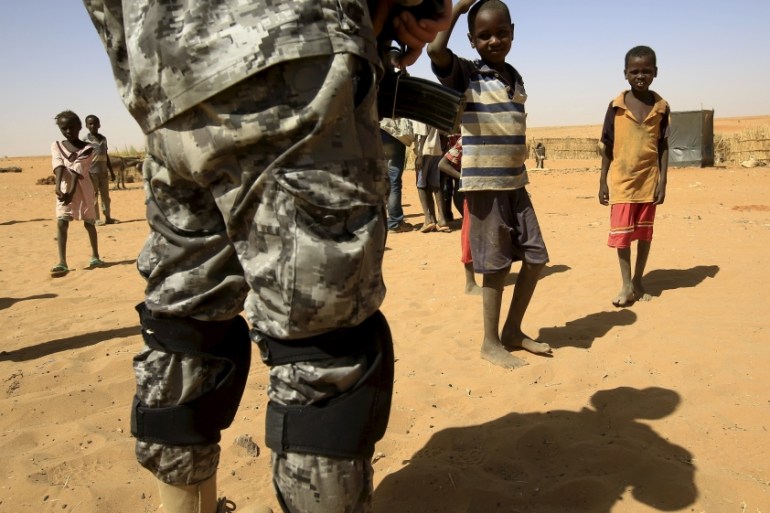 Newly arrived children look towards a UNIMED peacekeeper at the Zam Zam IDP camp, near Al Fashir in North Darfur