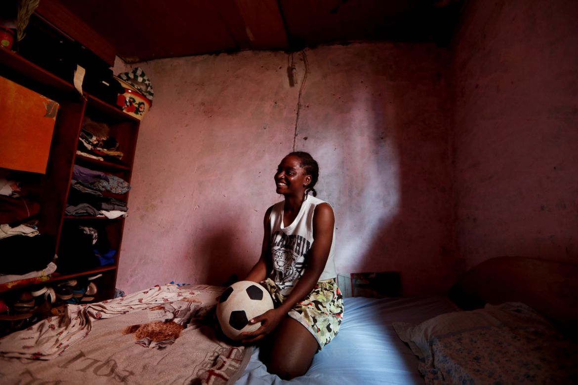 Ida Daniela Pouadjeu, 16, a soccer player who is amongst the first wave of girls being trained by professional coaches at the Rails Foot Academy, smiles as she sits on her bed in Yaounde, Cameroon, Ma