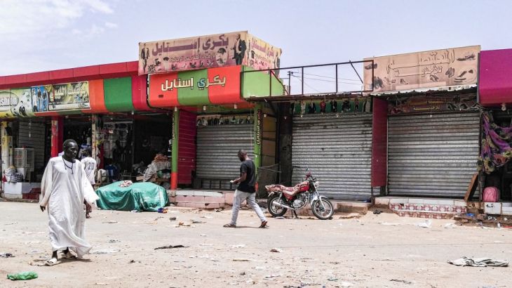 Sudanese men walk past closed shops in the capital Khartoum on June 11, 2019, on the third day of a civil disobedience campaign launched by protest leaders after a crackdown on a weeks-long sit-in lef