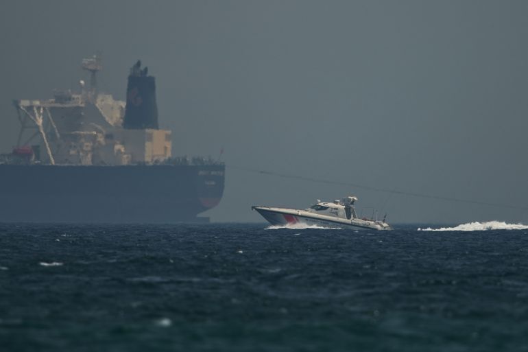 An Emirati coast guard vessel passes an oil tanker off the coast of Fujairah