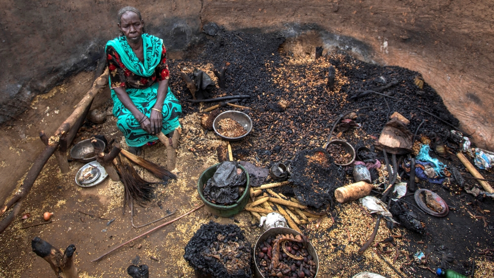 A woman sits in a burnt house during the clashes between nomads and residents in Deleij village, located in Wadi Salih locality, Central Darfur, Sudan June 11, 2019. Picture taken June 11, 2019. REUTE