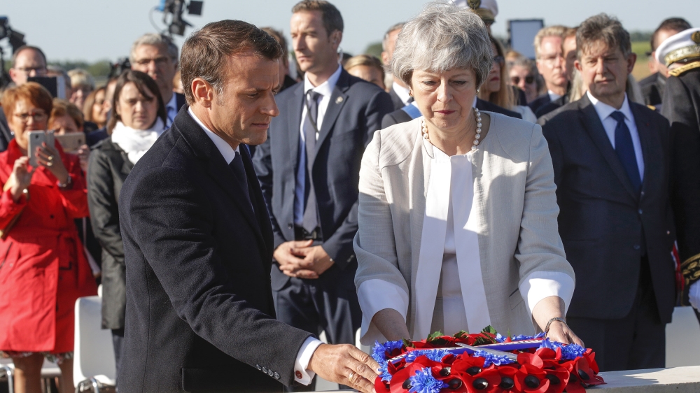 British Prime Minister Theresa May and French President Emmanuel Macron, left, lay a wreath of flowers at the commemorative first stone for a British memorial during a Franco-British ceremony to mark 