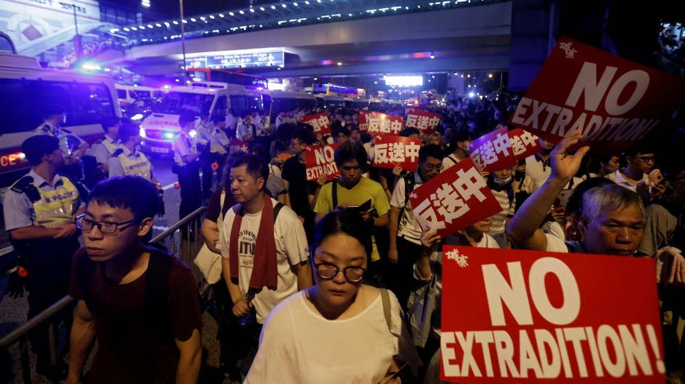 Demonstrators hold signs during a protest to demand authorities scrap a proposed extradition bill with China, in Hong Kong