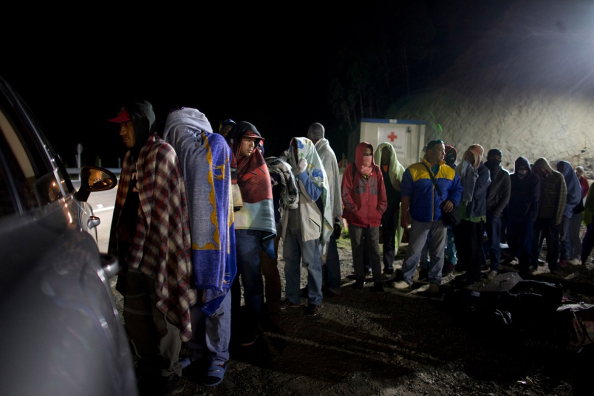 In this Aug. 31, 2018 file photo, Venezuelan migrants line up for free bread and coffee, donated by a Colombian family from their car, at a gas station in Pamplona, Colombia. A record 71 million peopl