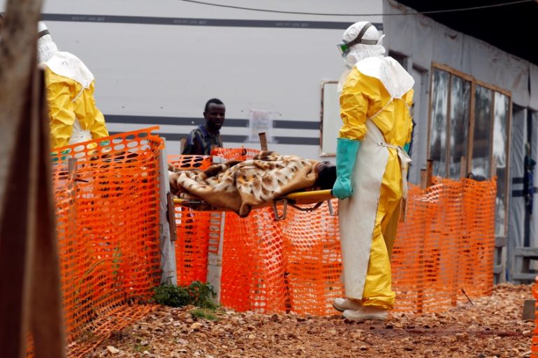 Health workers carry a newly admitted confirmed Ebola patient into the Red zone of the Ebola treatment centre in the Eastern Congolese town of Butembo