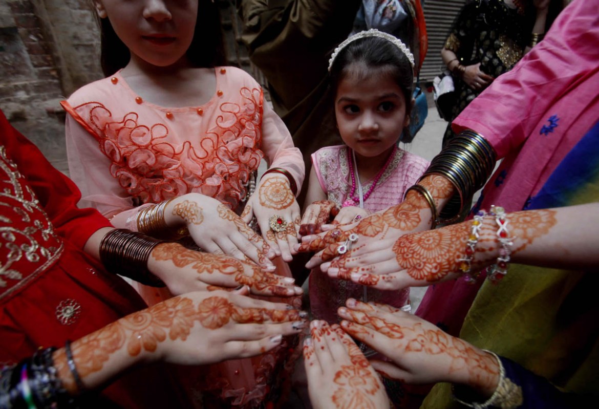 Muslims girls show their hands painted with henna to celebrate the Eid al-Fitr, which marks the end of the holy fasting month of Ramadan at a Mosque in Peshawar, Pakistan, Tuesday, June 4, 201 (AP Pho