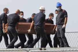 The casket of one of the migrants who died when their boat capsized off in the Canal of Sicily is carried aboard a Italian Navy ship at the Lampedusa island harbor, Saturday, Oct. 12, 2013.