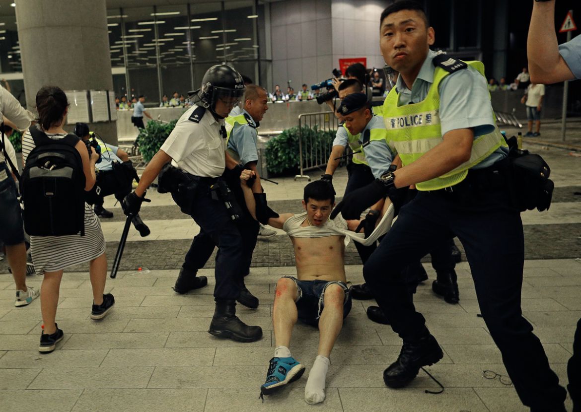 Hong Kong police officers drag away a protester during a rally against proposed amendments to the extradition law at the Legislative Council in Hong Kong during the early hours of Monday, June 10, 201