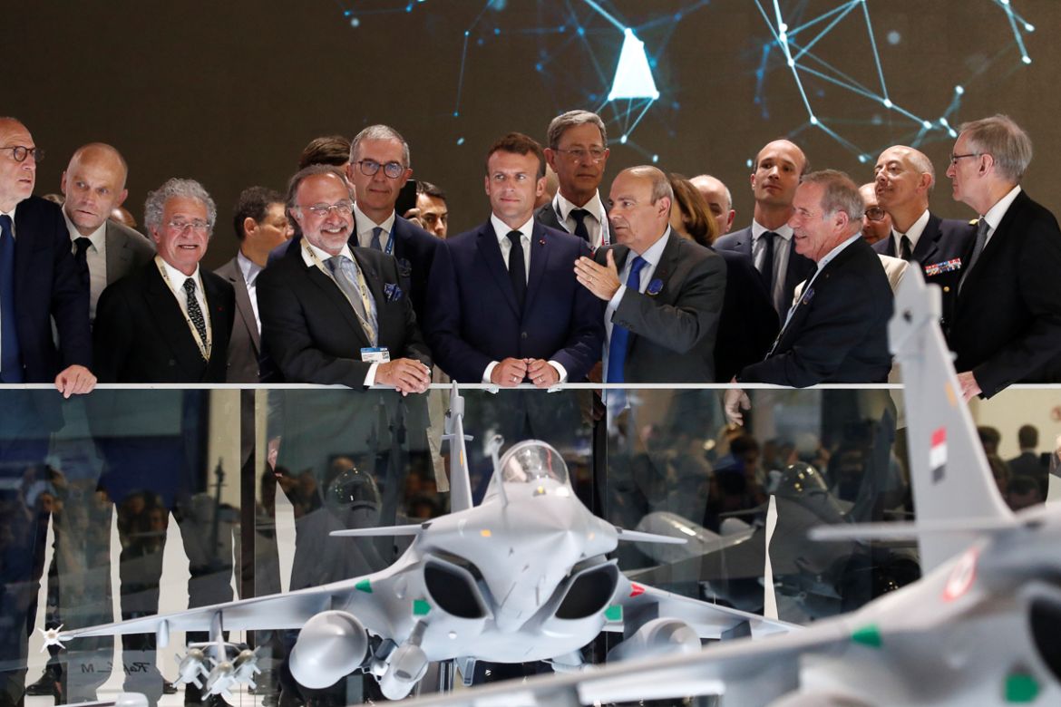 French President Emmanuel Macron, listens to Eric Trappier, Chairman and CEO of Dassault Aviation, next to Olivier Dassault and French Defence Minister Florence Parly during a visit at the 53rd Intern