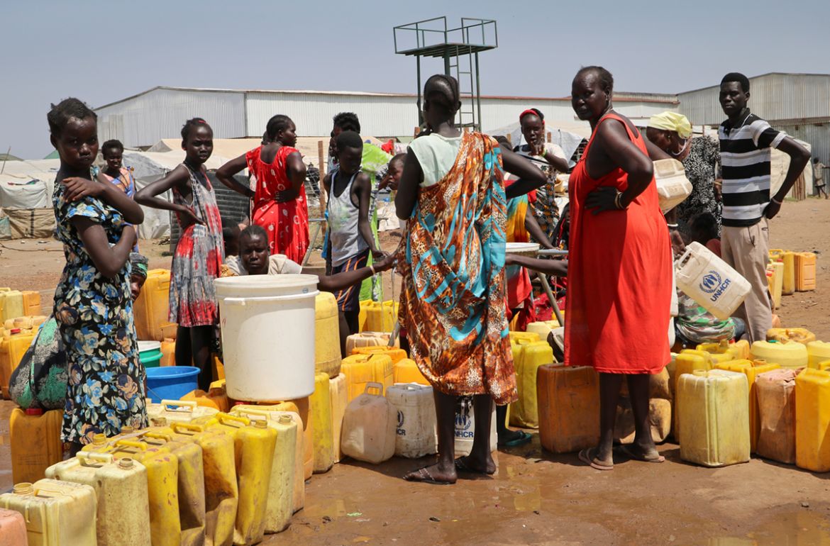 in this photo taken Tuesday, Jan. 22, 2019 residents of the Mangateen camp for the internally-displaced line up to get water from a borehole, on the outskirts of the capital Juba, South Sudan. Tens of