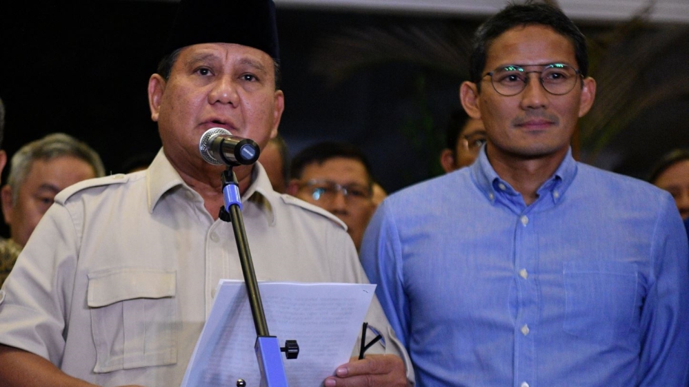 Indonesia's presidential candidate Prabowo Subianto delivers a speech as his running mate Sandiaga Uno listens in Jakarta