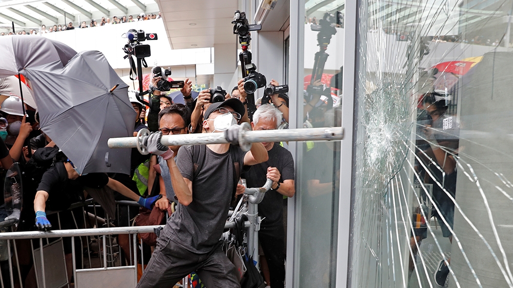 Protesters try to break into the Legislative Council building where riot police are seen, during the anniversary of Hong Kong's handover to China in Hong Kong, China July 1, 2019.  REUTERS/Tyrone Siu 