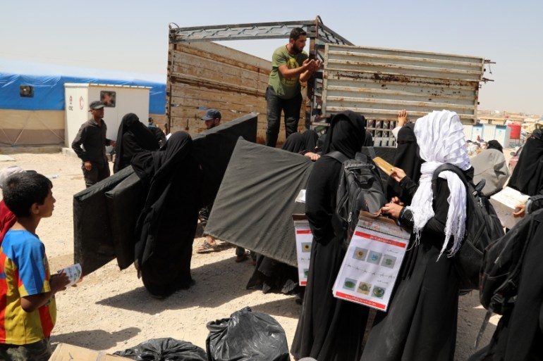 Wives of Islamic state fighters (IS) load their belongings into a truck upon their deportation from the al-Hol camp for refugees in al-Hasakah governorate in northeastern Syria on 03 June 2019
