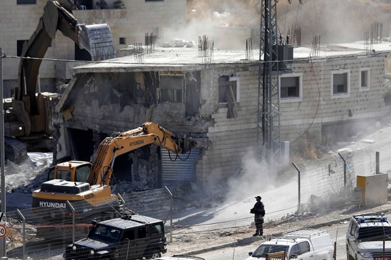 An Israeli army bulldozer demolishes a building in the Palestinian village of Sur Baher, in East Jerusalem, 22 July 2019. Israeli authorities decided to demolish at least six Palestinian residential b