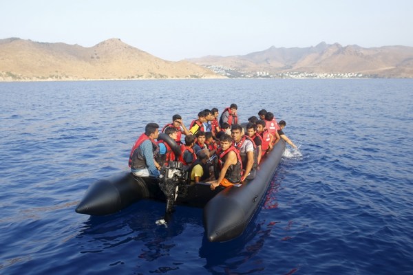 Група от 14 бежанци и мигранти и тялото на мъж