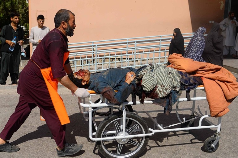 Graphic content / An injured Afghan man is transported on a stretcher after being injured when a bus hit a roadside bomb on the Kandahar-Herat highway, at a hospital in Herat on July 31, 2019. - Dozen