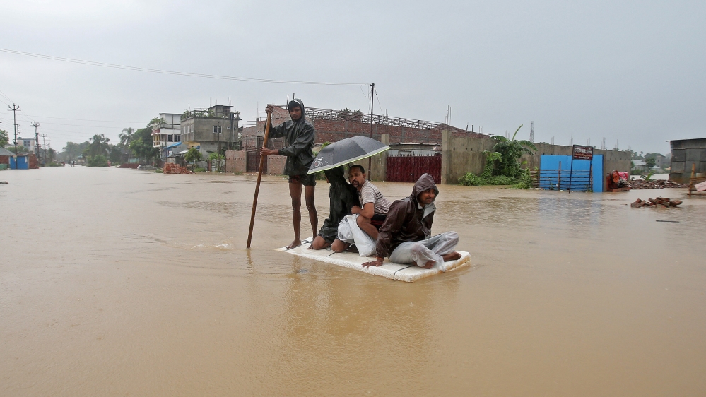 Villagers use a makeshift raft to cross a flooded area on the outskirts of Agartala, India, July 15. REUTERS/Jayanta Dey