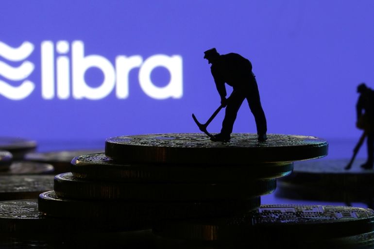 Small toy figures are seen on representations of virtual currency in front of the Libra logo in this illustration picture, June 21, 2019. REUTERS/Dado Ruvic/