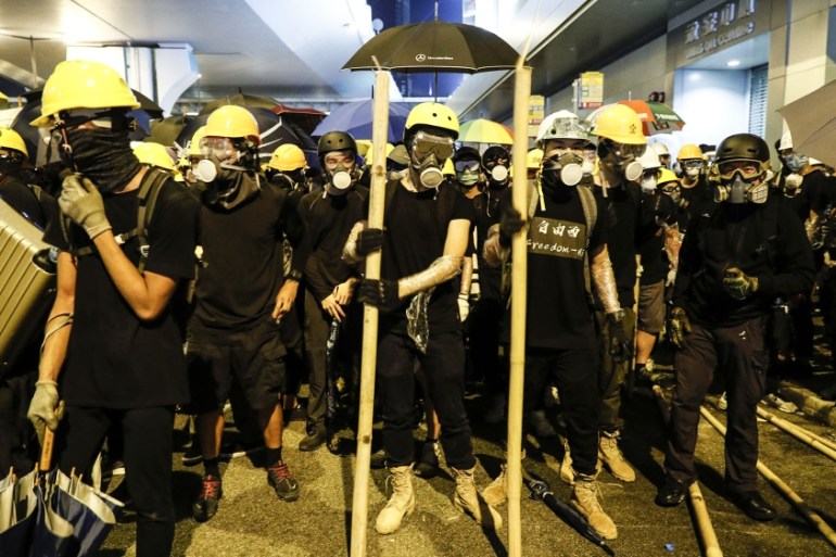 Protesters prepare to confront riot police in Hong Kong on Sunday, July 21, 2019. Protesters in Hong Kong pressed on Sunday past the designated end point for a march in which tens of thousands repeate