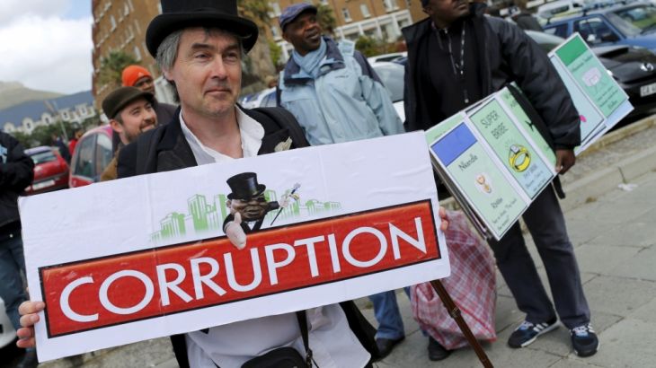 Demonstrators carry placards as they march to protest against corruption in Cape Town